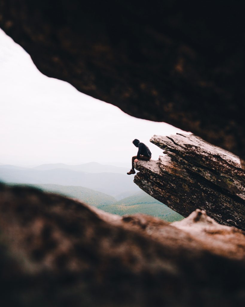 man sitting in a rock formation