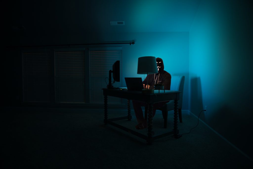 person in a mask inside a dark room