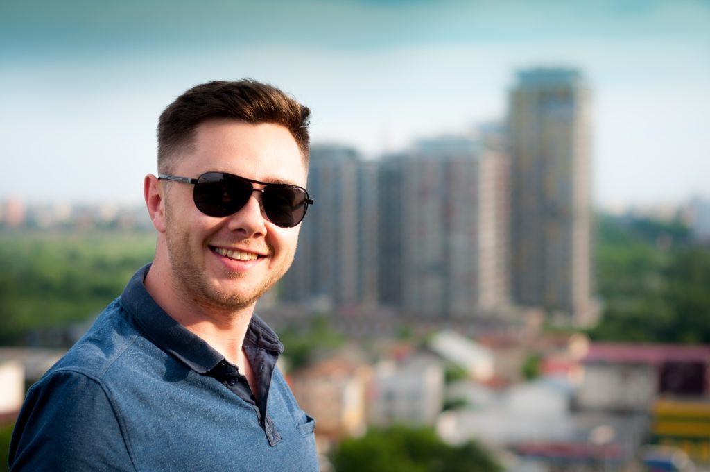 portrait picture of a man with a blurry building background