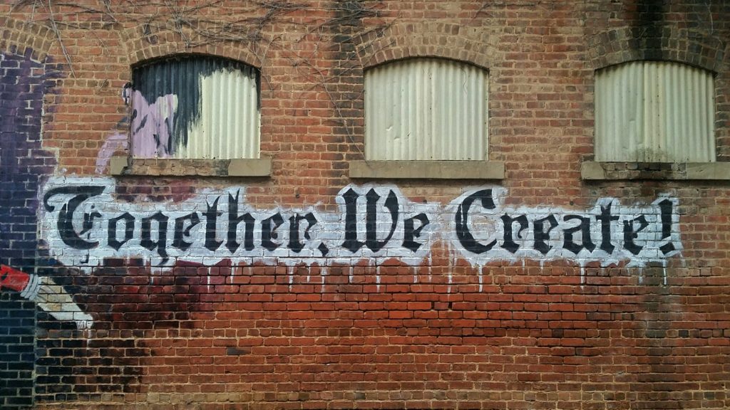 painted sign on the wall of together we create