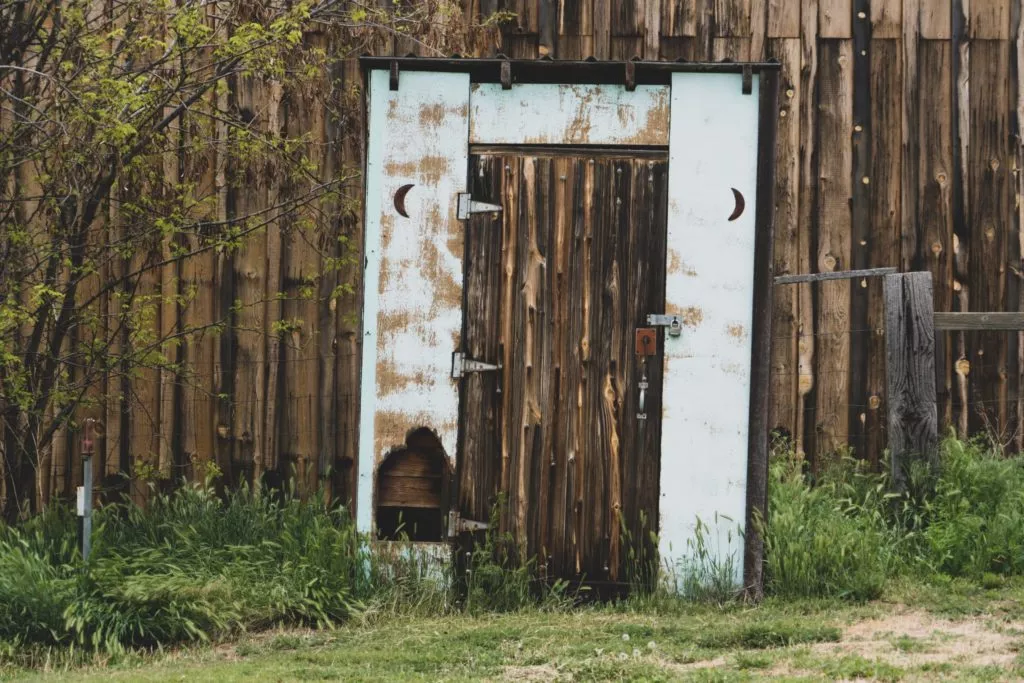 outside toilet with wooden door