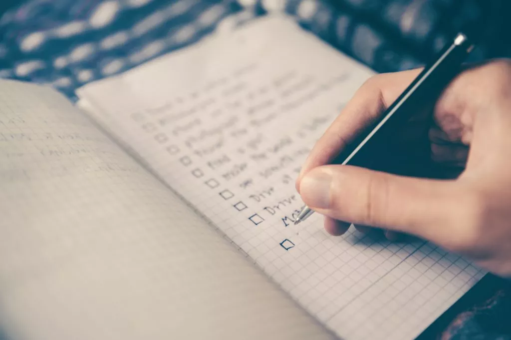 man writing a checklist
