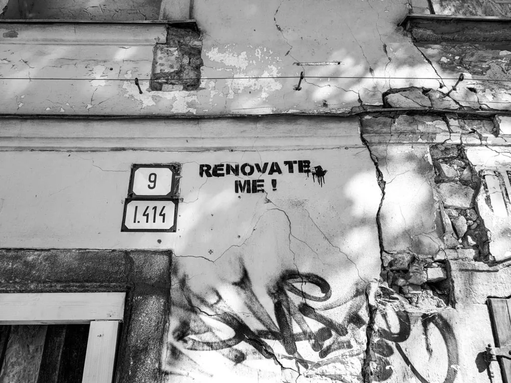 Wall of a building that says "renovate me"