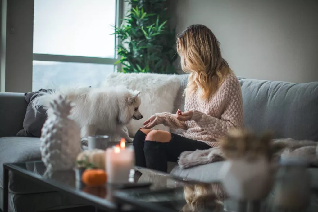 lady sitting on couch with her dog