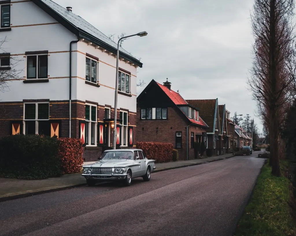 classic car parked outside a 2-storey house